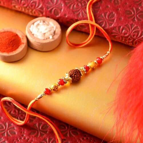 Red -orange beads with rudraksh rakhi , Besan ladoo and Thali