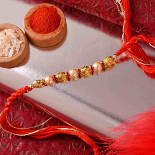 Golden Pearl Rakhi With Dual-Toned Thread