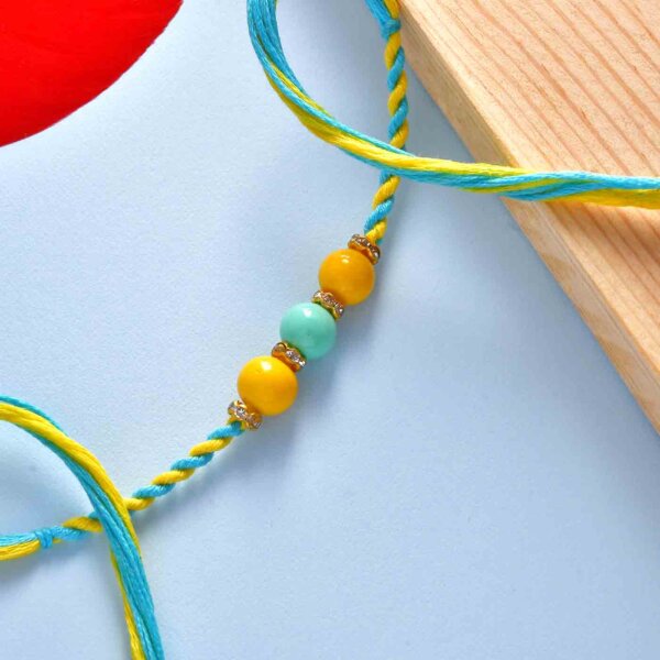 Set Of 2 Blue & Yellow Beads Rakhis With Chocolate Dipped Blueberry Dates (100 Gms)- FOR USA