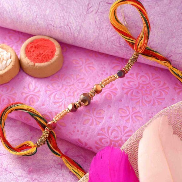 Golden Pearl Rakhi With A Multi-Toned Thread