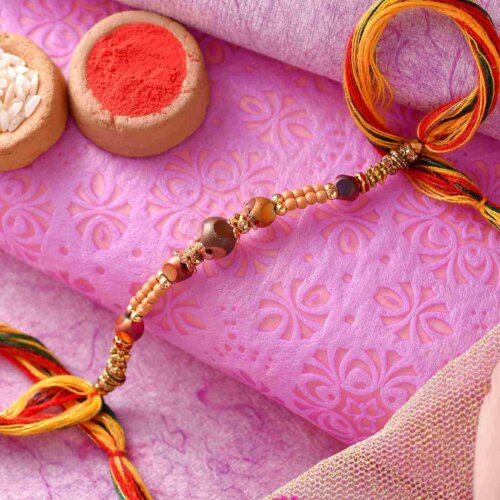 Golden Pearl Rakhi With A Multi-Toned Thread